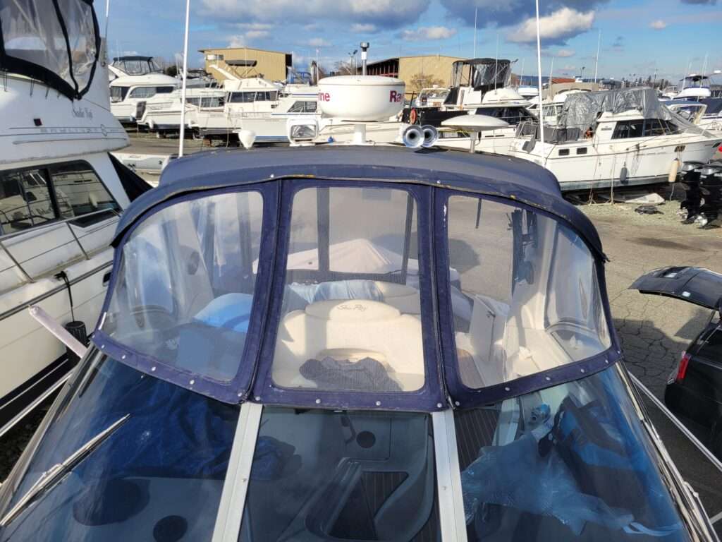 Navy blue front enclosure curtain with clear windows on a cabin cruiser